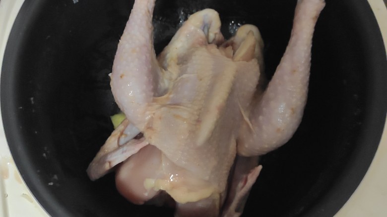 电饭煲盐焗鸡,把鸡放进刚加热好的电饭锅选煮饭功能,完成一次后把鸡翻过来再煮一会即可