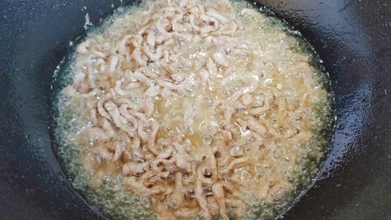 芹菜木耳炒肉丝,起油锅,油热后下肉丝,翻炒至变色