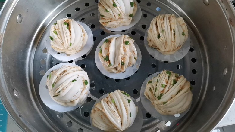 芝麻香葱花卷,做好垫上油纸,放入蒸锅,二次发酵十分钟,水开上锅蒸15分钟,焖三分钟,即可取出