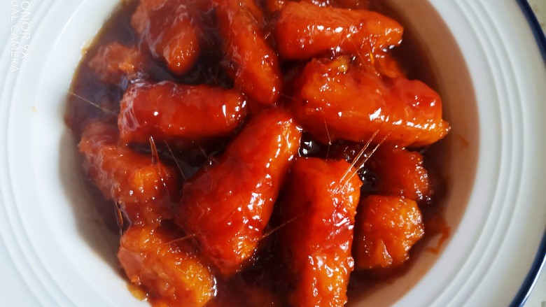 拔丝南瓜,随着糖浆慢慢变凉,南瓜的颜色会越来越深,能够看得到糖丝,夹起南瓜能够拔长的金丝