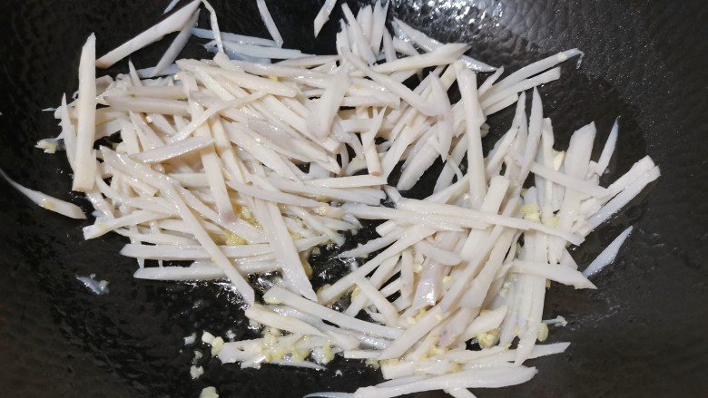 炒藕丝,再把莲藕丝放入,加入食用盐翻炒均匀
