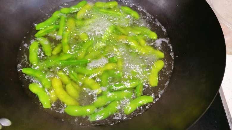 小炒毛豆,大火煮开一两分钟,煮至毛豆剪开的地方有一点裂开