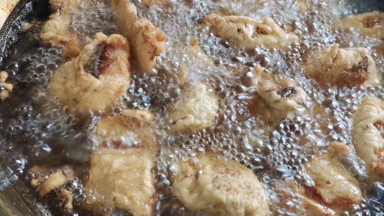 椒香鱼块,米锅烧油,油温六成热,下入鱼块,小火炸至表面金黄捞出