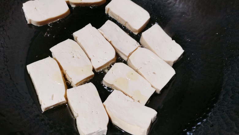 鸡蛋炖豆腐,热锅冷油,把豆腐擦干水分,再把它放入锅里,小火慢煎