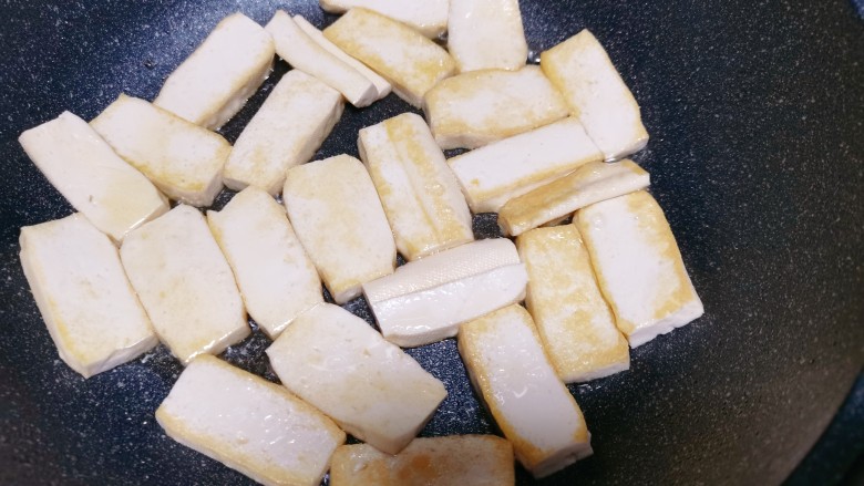 孜然煎豆干,平底锅里刷上一层油,再把切好的豆腐放入锅中,小火慢煎