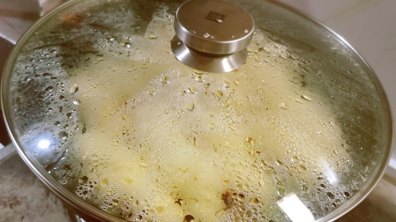 豆角焖卷子,扣上锅盖,约12分钟焖熟。