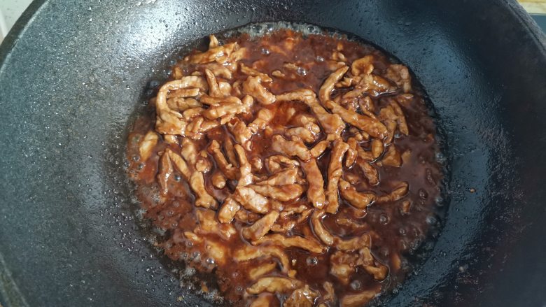 京葱炒肉丝,倒入滑好的肉丝翻炒均匀,使肉丝均匀的沾上酱汁