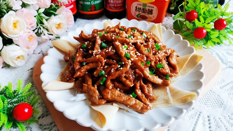 京葱炒肉丝,把肉丝盛在盘子中间,撒上葱花和白芝麻即可