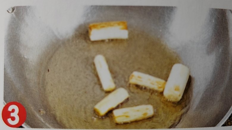 葱烧海参,放入葱白段,用中火炒至微黄,放入海参条炒匀