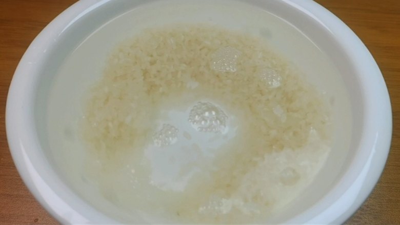 蛋黄养生粥,接下来准备100克的<a style='color:red;display:inline-block;' href='/shicai/ 492'>大米</a>,用清水把它清洗干净。