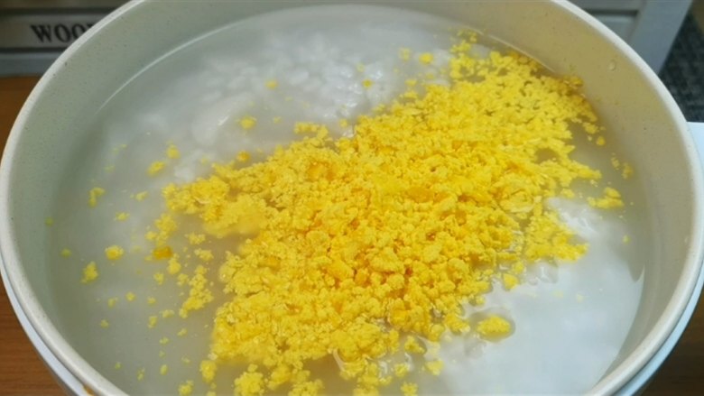 蛋黄养生粥,粥熬好以后,把鸡蛋黄倒进锅里来。