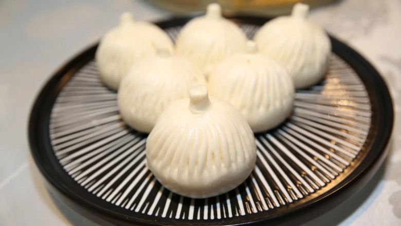 多汁鲜肉包子,将水烧开,把包子放入笼屉,上锅蒸制20分钟,这样白白胖胖的包子就做好了。