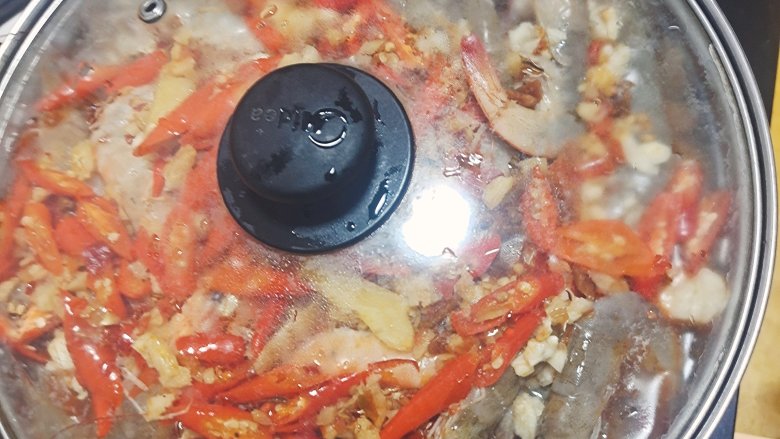 花甲粉丝煲(火锅),盖上盖子。放到电磁炉上煮开再煮一会,粉丝跟虾那些很快就熟了。