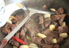 红烧牛肉面,炒至酒香夹着肉香的时候,大约一分钟,倒入热开水,末过牛肉的表面,大火烧开