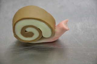 小蜗牛馒头,把身体压扁,涂一点水,把壳和身体粘结起来,就形成了一个个的小蜗牛