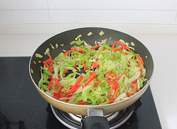 牛肉时蔬炒莜面,利用锅底的余油炒香蒜瓣,然后放入圆白菜丝炒至断生,然后放青红椒丝,调入3g的盐大火翻炒均匀。