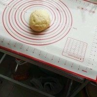 水果披萨,把发酵好的面团放在硅胶垫上撒点面粉,然后开始揉成面团,揉成不能沾手的面团。