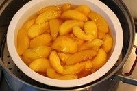 冰桃黄桃,水烧开后，把桃子放入锅中蒸25分钟左右~要加盖子~时间根据你切块的大小~还有喜欢的口感来定~喜欢吃软烂些的~最好在挑选黄桃的时候~就选择熟透的那种~像我爱吃脆的~~就买的离熟透还差点的~