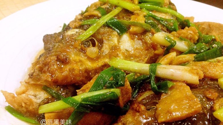 冻豆腐焖鱼头,装盘时先把鱼头和冻豆腐装进盘里,再往锅里余下的汤汁补一勺食用油,拌匀,浇在鱼头上面。