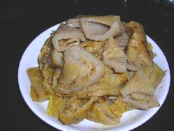 苕粉炒腊肉,将红苕粉调成芡汁，放在油锅中煎成饼，再切成小块