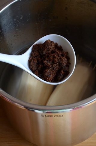 蜜汁藕,将灌好的藕放入锅中,加水,水量没过藕即可。加入红糖,撒一小把冰糖