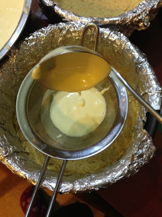 柠檬芝士蛋糕,现在预热烤箱150度,最重要的了,把糊糊装入冷冻过的饼底里面,装的时候要过筛,筛筛筛;