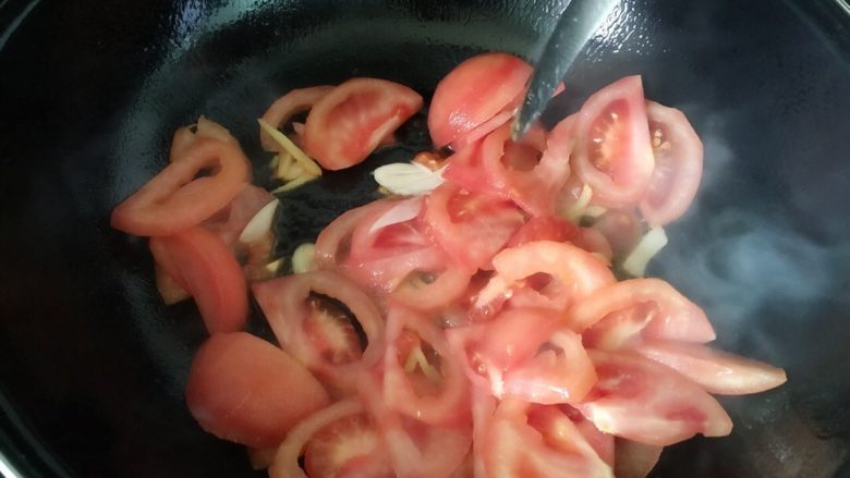 番茄猪肝汤,先把锅烧倒油,放入姜蒜炒香,再倒入切好的番茄翻炒。