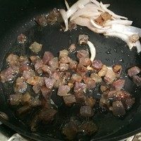 腊肠牛肝菌炊饭,洋葱炒软后推至一旁,下腊肠丁翻炒,会慢慢炒出些许油脂