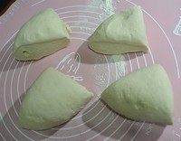 小花卷,发酵好的面团放在案板上再反复揉一揉让它排气。因为我用的硅胶垫,面积小,所以把面团切开成了四份。如果有大案板也可以不用切。