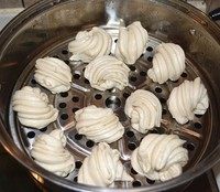 小花卷,蒸锅加冷水,篦子上刷一层油防粘,把花卷放进去,摆放的时候稍微离开一点距离。先用小火慢慢加温,这样做是为了让花卷先完成醒发,大约十五到二十分钟左右,转大火开锅后蒸10分钟关火。
