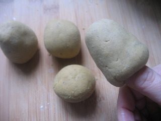 粗粮小窝头,揉搓成小圆球。右手沾点凉水,在面球中间钻1个小洞,边钻边转动手指,左手拇指及中指同时协同捏拢