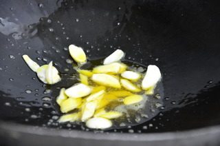 仔虾荷包蛋,锅中淋入少许豆油，把蒜片放入稍煸
