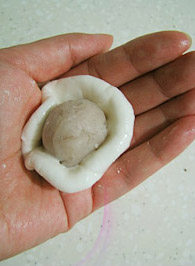 冰晶雪花饺,将饺皮分割成20克左右的小团，用手揉圆后用双掌压平些，再包入内馅，捏揉成团；