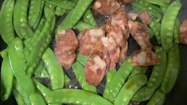 荷兰豆炒腊肠,加入腊肠继续翻炒,新手不好掌控生熟可再加入适量水煮沸翻炒。