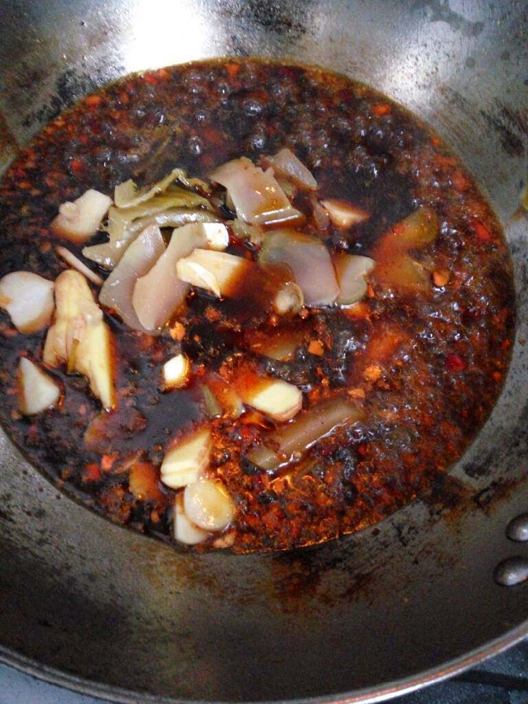 鱼蔬一锅端之麻辣火锅鱼,锅中倒油,多倒点,油热后放入几勺豆瓣,一袋火锅料,翻炒均匀后倒入切好的配件翻炒,小火慢炒,至香味弥漫,整个过程大概四分钟