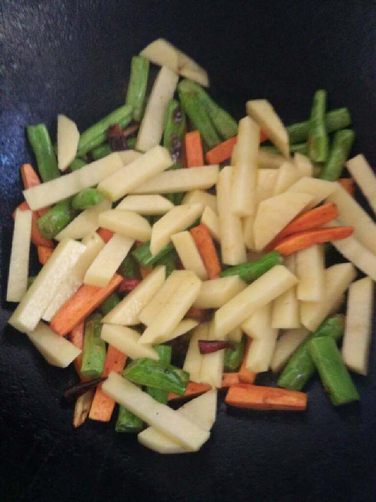 地方菜 干煸三素,将豆角和胡萝卜煸炒半熟后倒入土豆条煸炒10分钟左右放入盐 香油