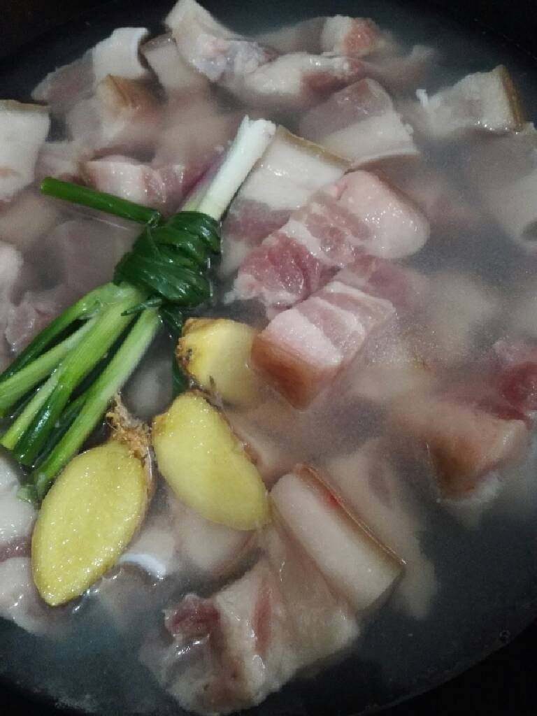 地方菜 毛氏红烧肉,把烙好皮的五花肉洗净切块。锅中加入水,放入切好五花肉,姜片,葱结,<a style='color:red;display:inline-block;' href='/shicai/ 718'>料酒</a>焯水后捞出。