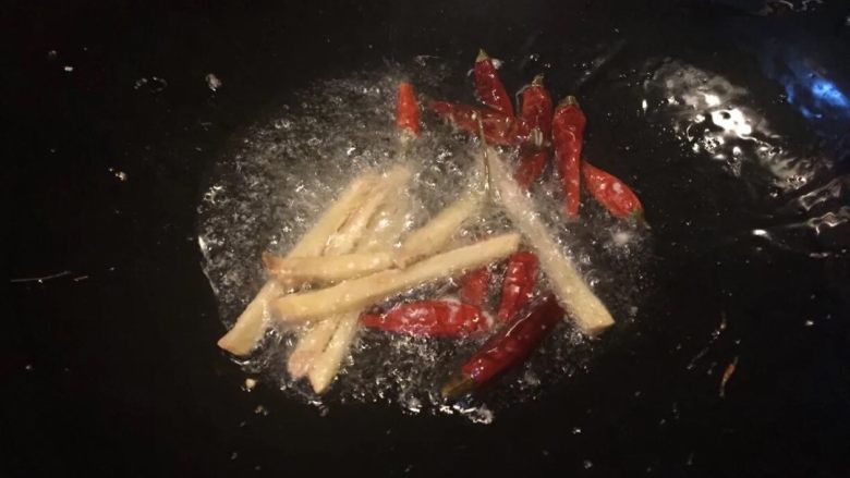 地方菜香辣肉丝,热锅冷油,油热加入姜丝,干辣椒炒香