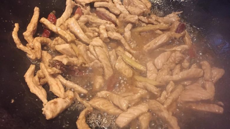 地方菜香辣肉丝,淋入一匙半酱油翻炒上色