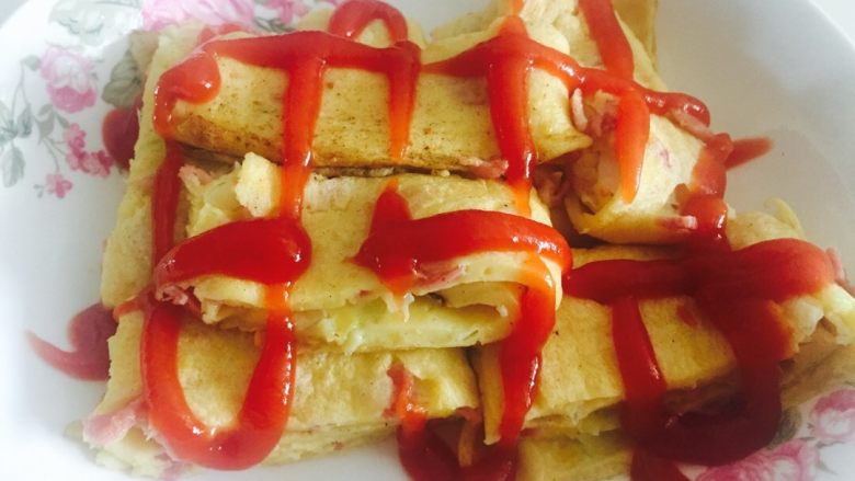 培根蛋烧,把 <a style='color:red;display:inline-block;' href='/shicai/ 11621'>培根肉</a>  <a style='color:red;display:inline-block;' href='/shicai/ 519'>面粉</a>  <a style='color:red;display:inline-block;' href='/shicai/ 9'>鸡蛋</a> 葱花加适量水搅拌成糊状  加入盐和<a style='color:red;display:inline-block;' href='/shicai/ 720'>胡椒粉</a>。放入电饼铛摊饼。  快熟的时候将饼卷起。在电饼铛里稍微压结实。出锅后切成块 放一点番茄酱 或喜欢的卡夫酱都可以。  配一碗小米粥或牛奶  一级棒的早餐！我家大宝跟喜欢💖