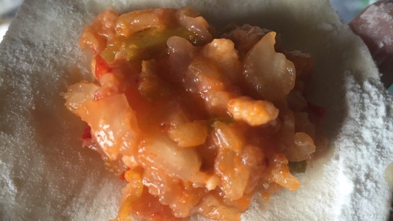 泡菜饺子,适量的馅料放于皮中间,自己吃其实不用很好看,只要里面的料不出来就可以了