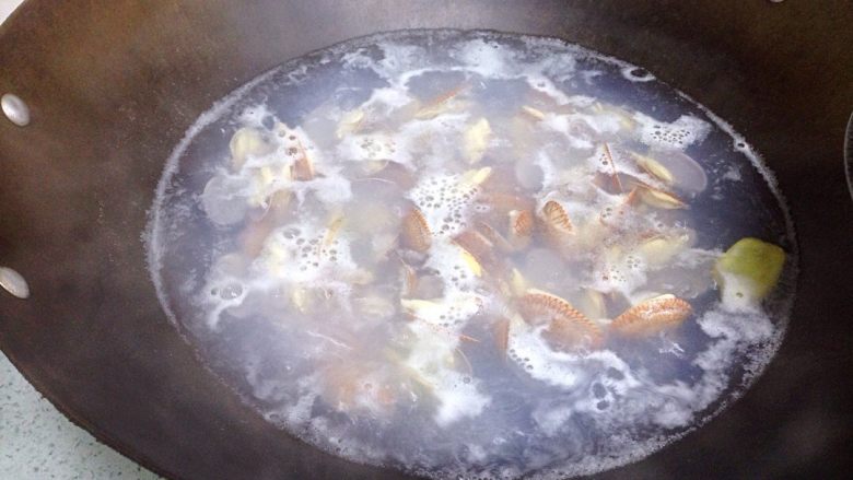 地方菜 姜葱炒花蚬,锅里倒入足量清水,放几片姜片煮开后,倒入花蚬,继续大火煮至花蚬基本全部半开,倒至沥水蓝用清水冲洗干净花蚬里藏着的泥沙。