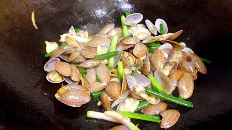 地方菜 姜葱炒花蚬,淋入适量生抽,撒入葱段,翻炒均匀。