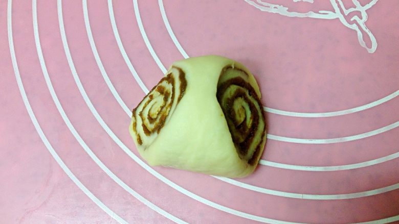 巧克力面包卷,取一块切割好的面团,轻搓整圆,窄面朝上。