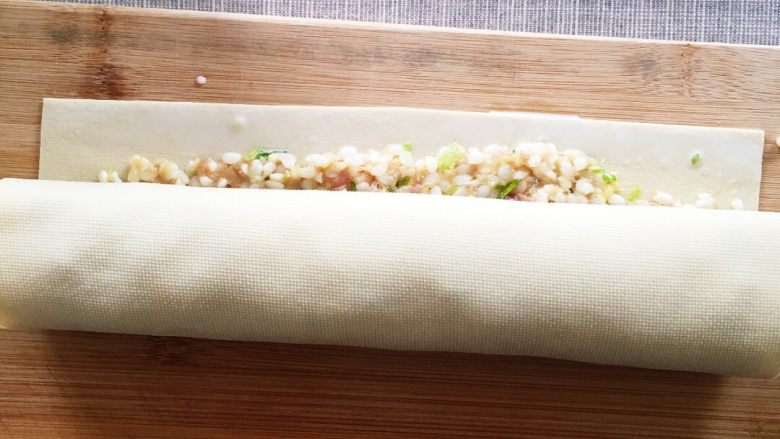 千张糯米肉卷,从一个边卷起来，要卷的紧一些，封口处涂抹水淀粉，把有封口的面朝下放入蒸笼里大约20分钟左右。