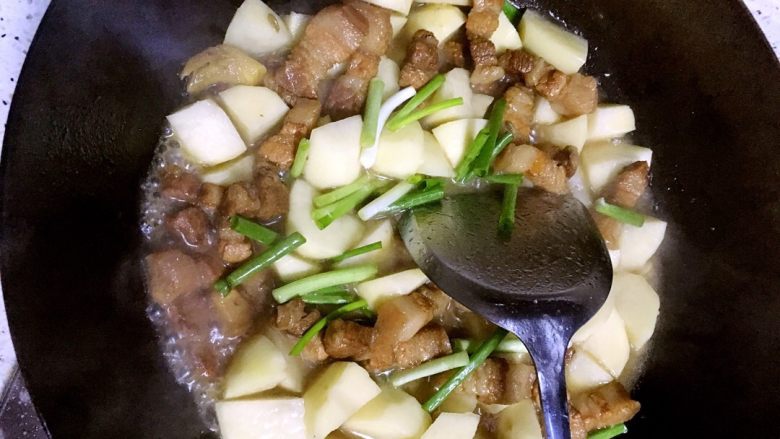 土豆烧五花肉,煮到肉差不多耙了放土豆和葱继续小火煮。