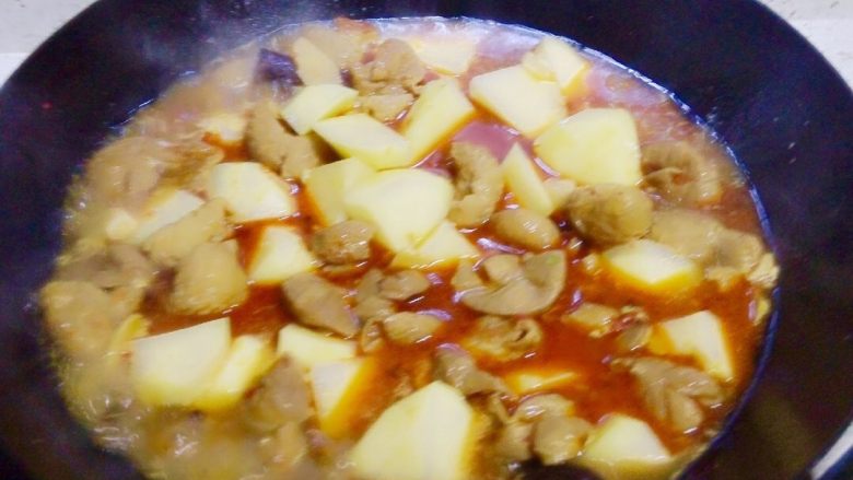 地方菜-土豆烧肥肠,将肥肠从压力锅里倒入炒锅,放入土豆。