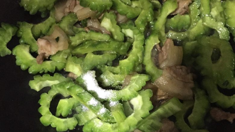五花肉炒苦瓜,待五花肉泛黄出油时加入苦瓜、盐、继续翻炒
