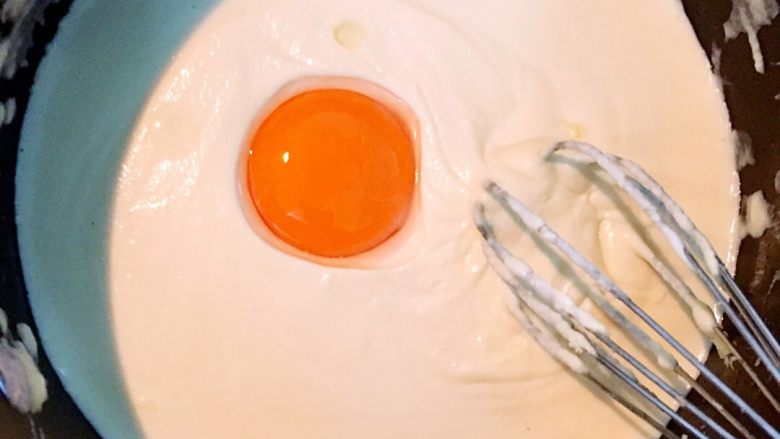 轻乳酪蛋糕,放入蛋黄快速搅拌均匀。如此反复将三个蛋黄逐个加入,蛋黄加入后一定要搅拌均匀才可以加下一个蛋黄。