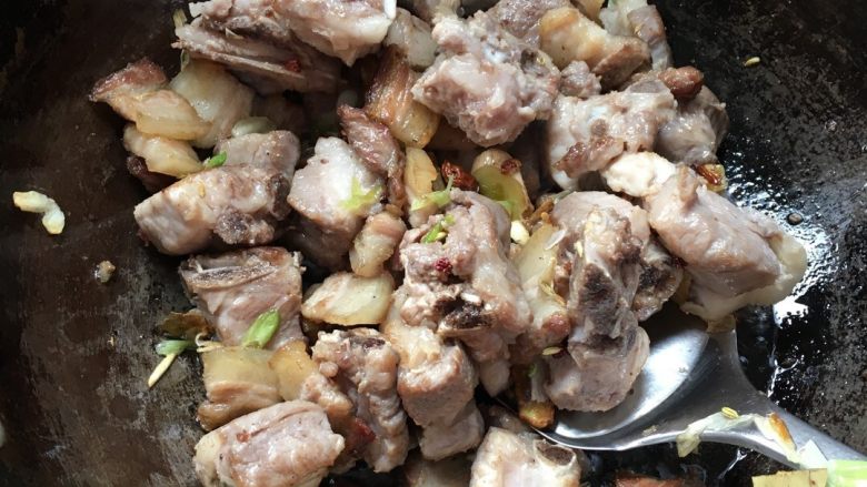 花肉排骨香菇炖豆腐,加入排骨和备料一同继续翻炒,炒至排骨表面金黄